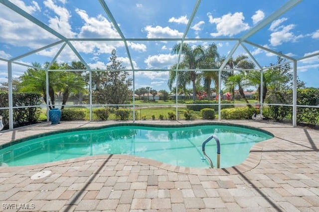 pool featuring glass enclosure and a patio