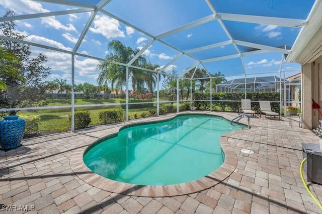 outdoor pool with a lanai and a patio area