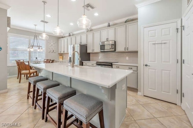 kitchen featuring light tile patterned flooring, visible vents, stainless steel appliances, and ornamental molding