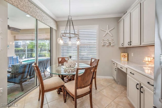 dining room with light tile patterned floors, baseboards, and crown molding