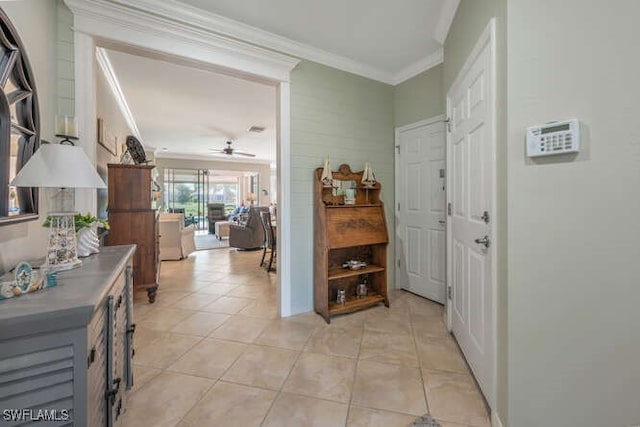 foyer with a ceiling fan, ornamental molding, and light tile patterned flooring