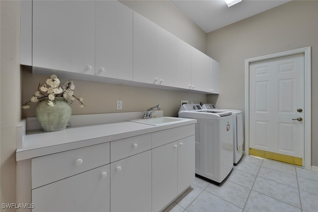 laundry area with washing machine and dryer, light tile patterned flooring, cabinet space, and a sink