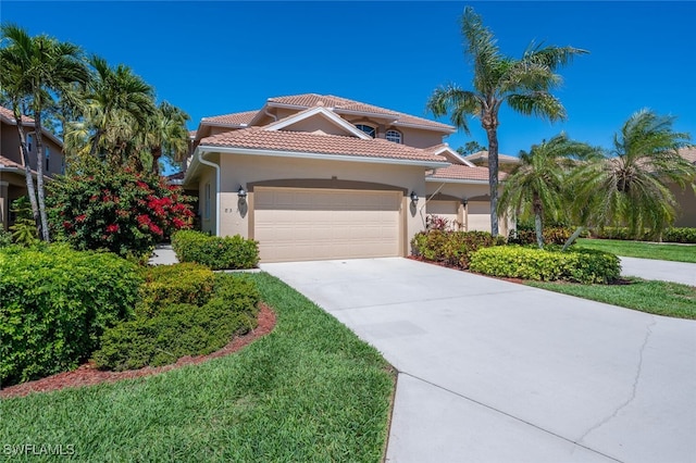 mediterranean / spanish-style house with a front yard, an attached garage, stucco siding, concrete driveway, and a tiled roof