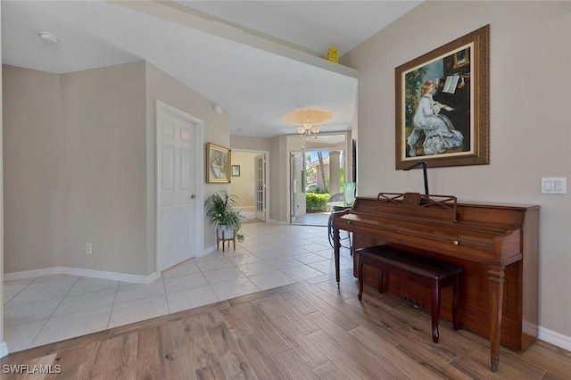 foyer with an inviting chandelier, baseboards, and wood finished floors