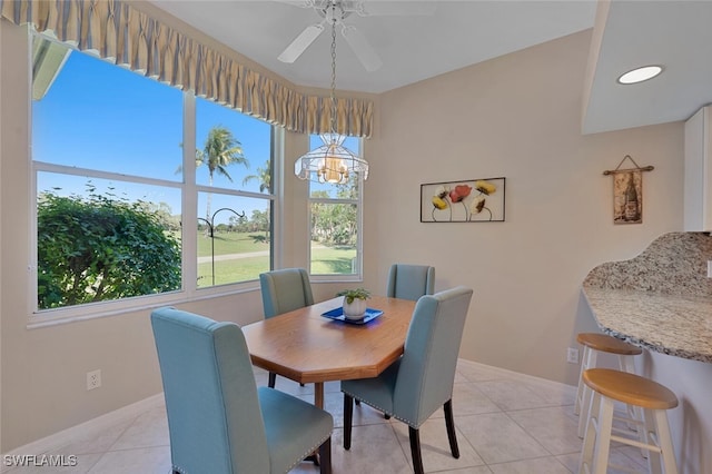 dining space featuring light tile patterned floors, baseboards, and ceiling fan