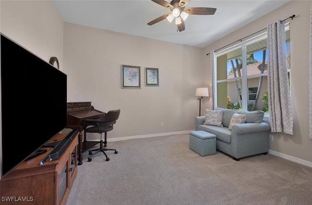 carpeted home office featuring baseboards and a ceiling fan