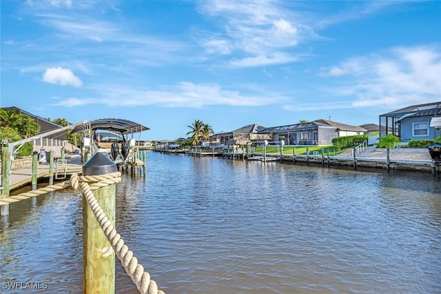 view of dock featuring boat lift, a residential view, and a water view