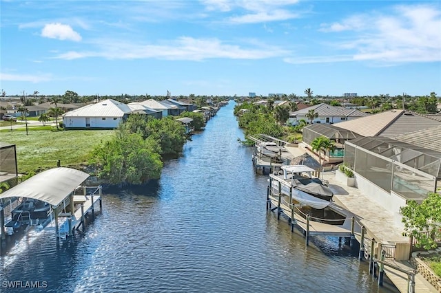 exterior space featuring boat lift, a lawn, a residential view, and a water view