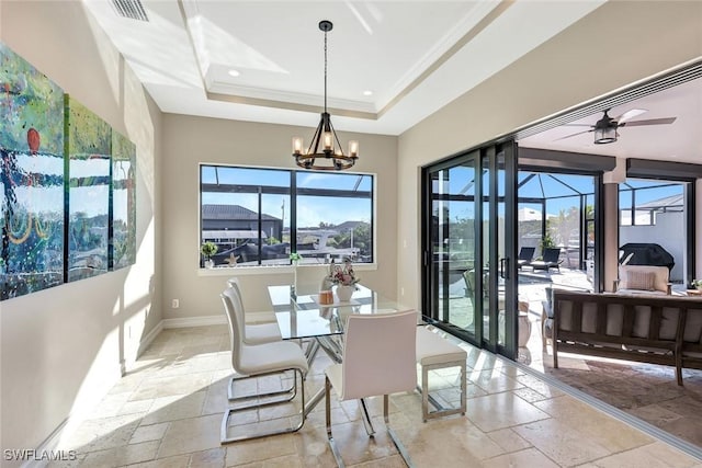 dining space with crown molding, baseboards, a tray ceiling, recessed lighting, and stone tile flooring