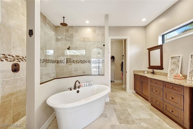 bathroom with a walk in shower, vanity, and baseboards