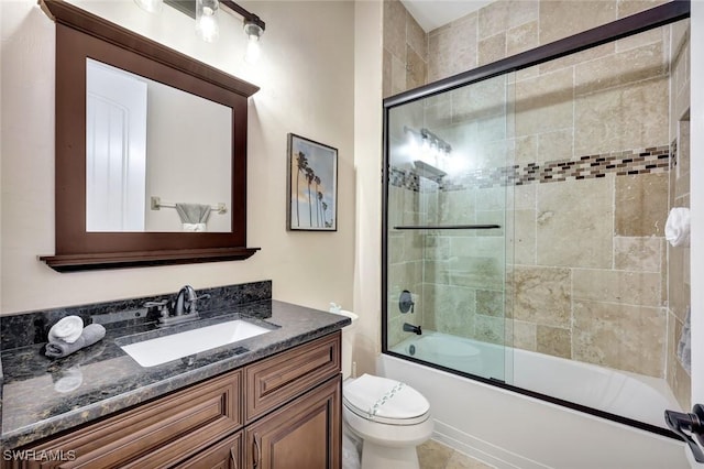 bathroom with vanity, toilet, and shower / bath combination with glass door