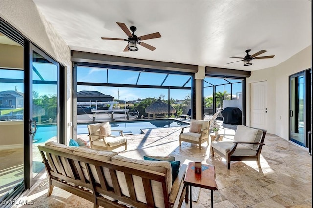 sunroom / solarium featuring ceiling fan