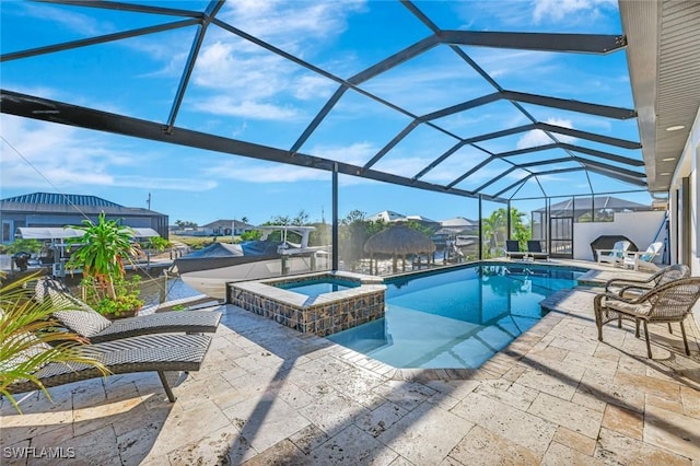 view of pool with a lanai, a pool with connected hot tub, and a patio