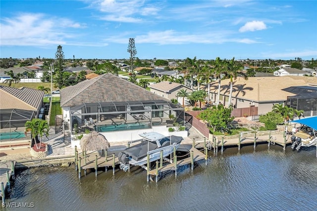 dock area with boat lift, glass enclosure, an outdoor pool, and a water view