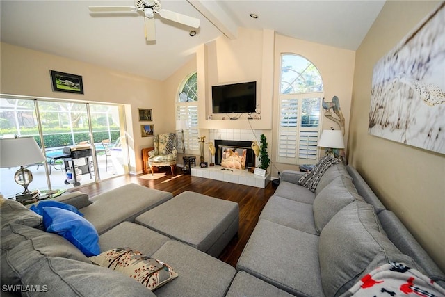 living room with vaulted ceiling with beams, baseboards, ceiling fan, a fireplace, and wood finished floors