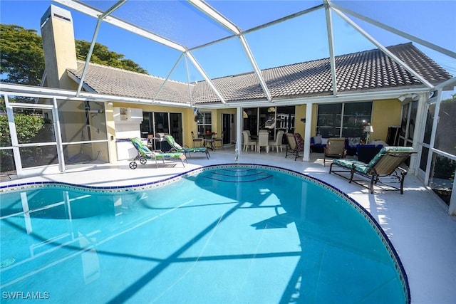 pool with a patio area and glass enclosure