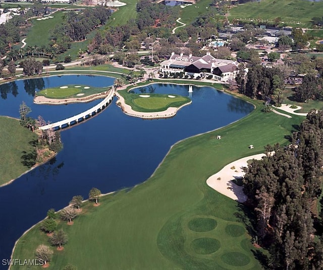 aerial view of property and surrounding area featuring a nearby body of water and a golf course