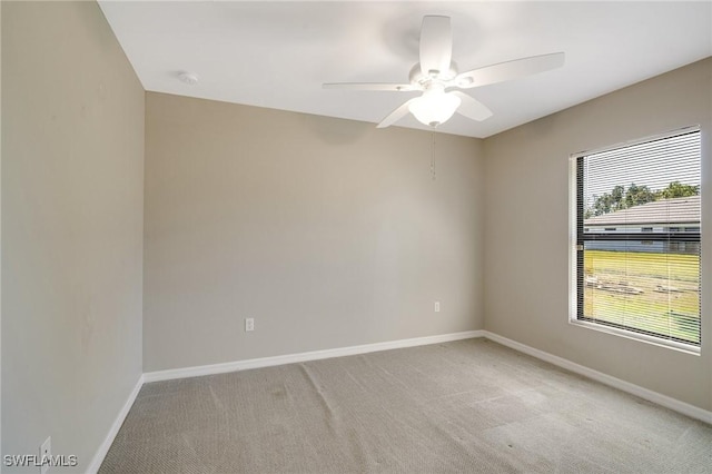 unfurnished room with baseboards, light carpet, and a ceiling fan