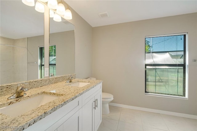 full bathroom featuring double vanity, toilet, baseboards, and a sink