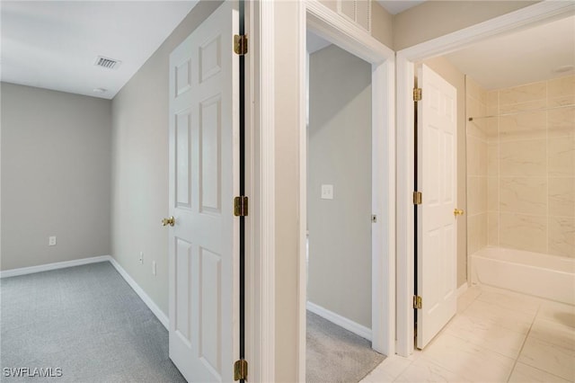 corridor with baseboards, visible vents, and carpet floors