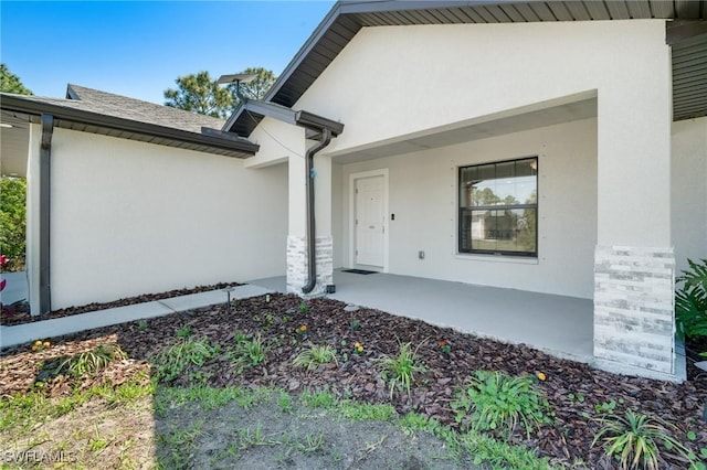 doorway to property featuring stucco siding