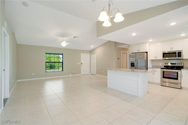 kitchen featuring white cabinetry, appliances with stainless steel finishes, a center island, and vaulted ceiling