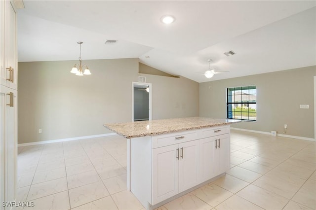 kitchen with vaulted ceiling, light stone counters, ceiling fan with notable chandelier, and visible vents