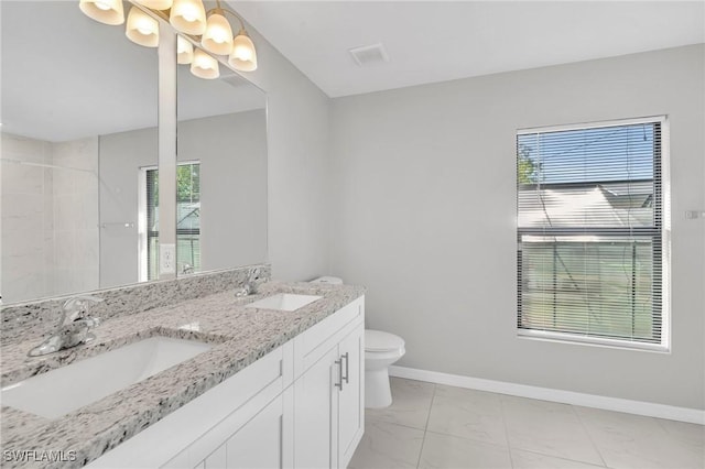 bathroom featuring a wealth of natural light, marble finish floor, a sink, and toilet