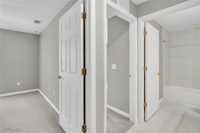 hallway with carpet flooring, visible vents, and baseboards