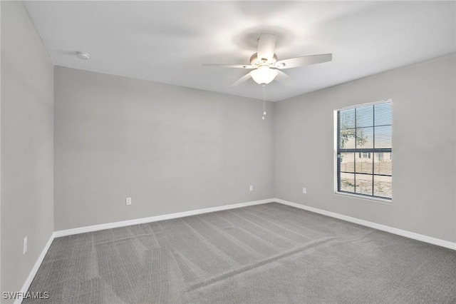 spare room featuring carpet flooring, baseboards, and a ceiling fan