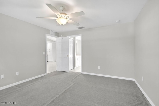 unfurnished room with visible vents, baseboards, a ceiling fan, and carpet flooring