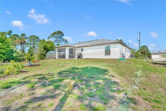 back of property featuring a yard and stucco siding