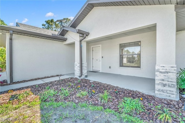 doorway to property featuring stucco siding