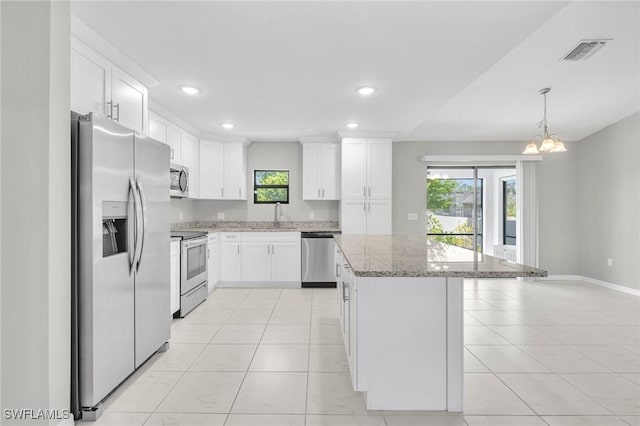 kitchen with visible vents, a healthy amount of sunlight, a kitchen island, and stainless steel appliances