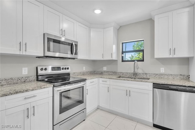 kitchen featuring white cabinets, a sink, light stone countertops, marble finish floor, and stainless steel appliances