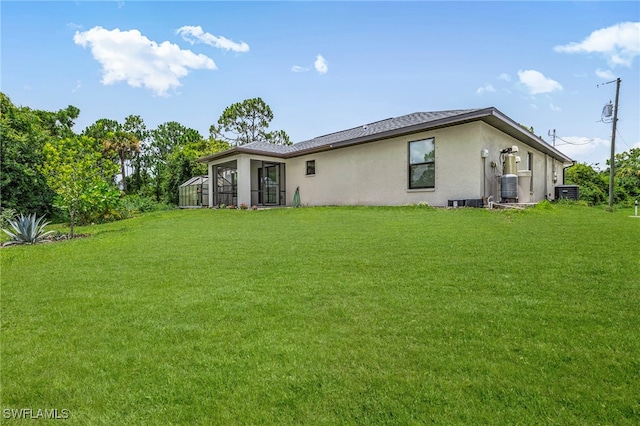 5303 4th St W, Lehigh Acres, FL 33971 - rear view of property with stucco siding and a yard