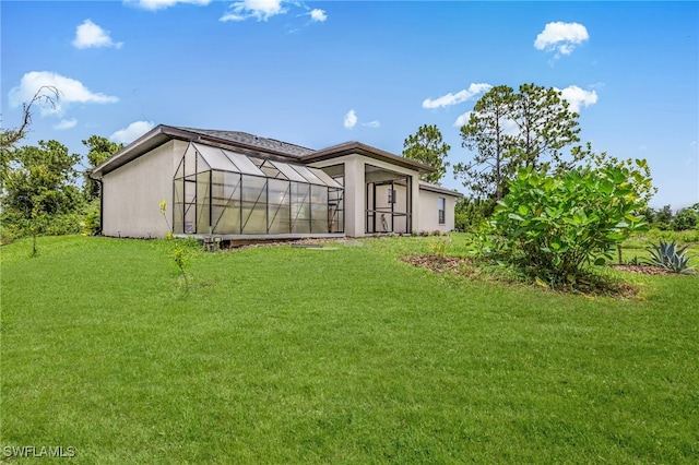 5303 4th St W, Lehigh Acres, FL 33971 - rear view of house featuring a lawn and stucco siding