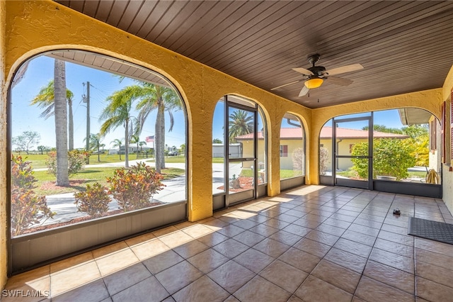 unfurnished sunroom with wood ceiling and ceiling fan