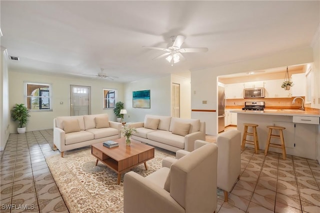 living area featuring visible vents and ceiling fan