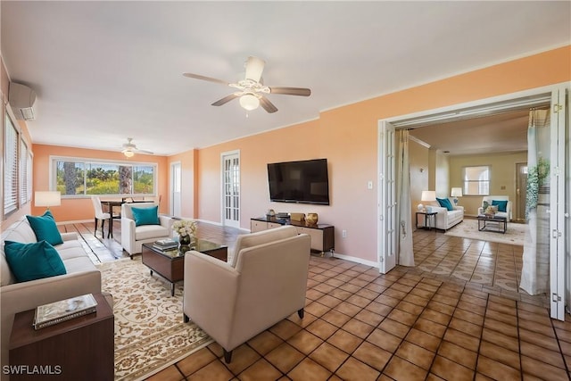 tiled living room featuring plenty of natural light, baseboards, a wall mounted air conditioner, and ceiling fan