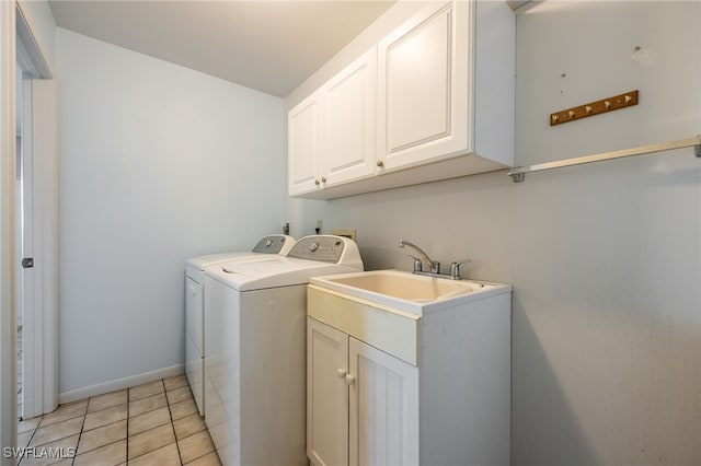 washroom featuring light tile patterned floors, cabinet space, baseboards, and separate washer and dryer