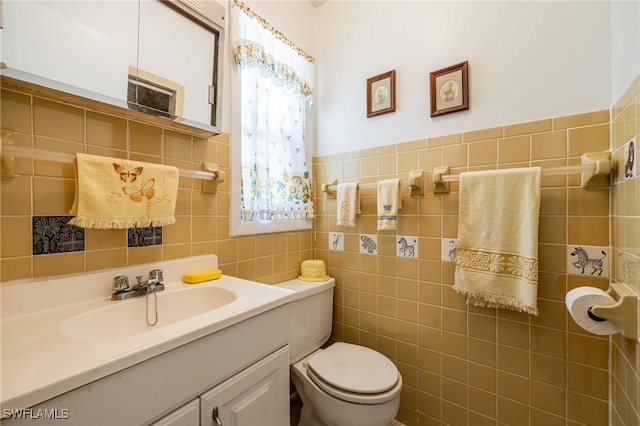 bathroom with toilet, tile walls, and vanity