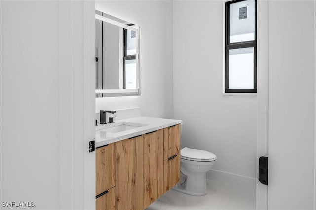 bathroom with toilet, vanity, and tile patterned flooring