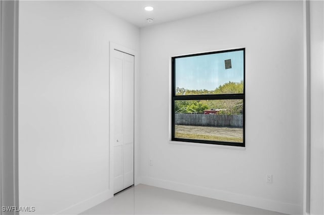 spare room featuring recessed lighting and baseboards