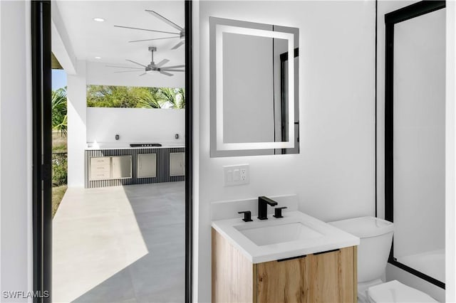 bathroom featuring plenty of natural light, toilet, floor to ceiling windows, and a ceiling fan