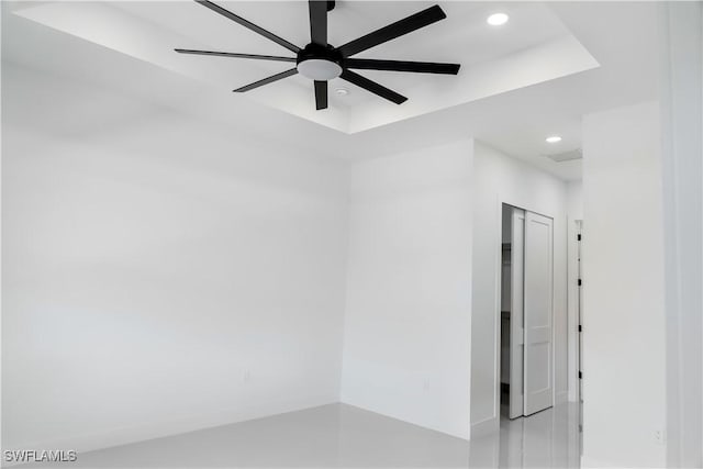 empty room with a tray ceiling, recessed lighting, and a ceiling fan