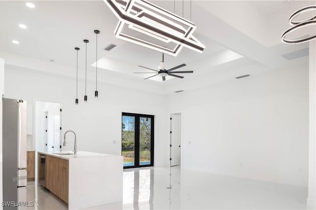 kitchen featuring visible vents, a sink, stainless steel appliances, a raised ceiling, and modern cabinets