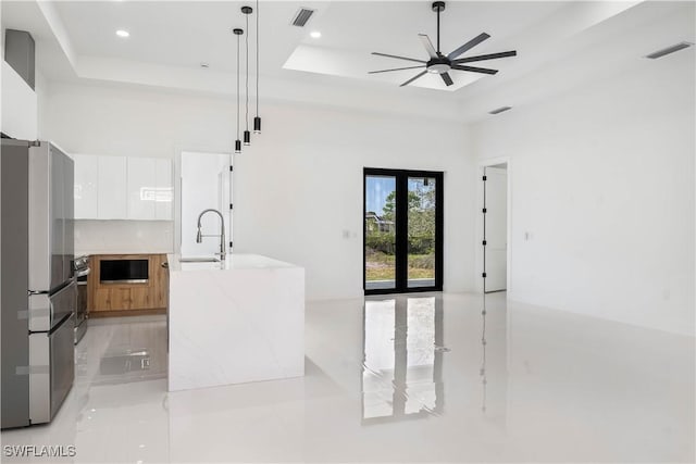 kitchen with modern cabinets, visible vents, appliances with stainless steel finishes, and a tray ceiling