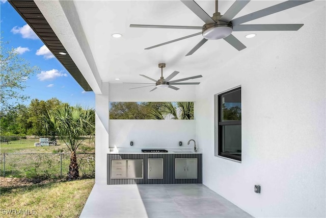 view of patio / terrace with a sink, area for grilling, a ceiling fan, and fence