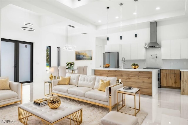 living area with a tray ceiling, a high ceiling, recessed lighting, and french doors